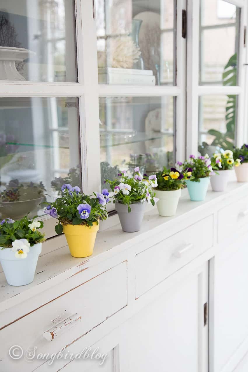 Painted terracotta pots along a mantel