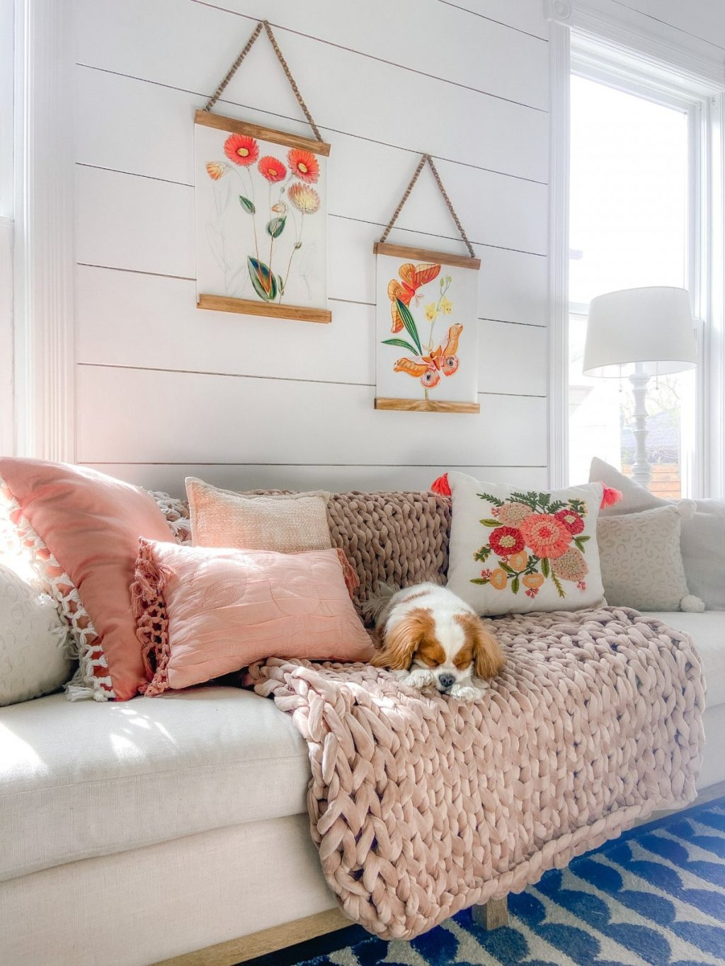 A cozy sofa and floral spring art above