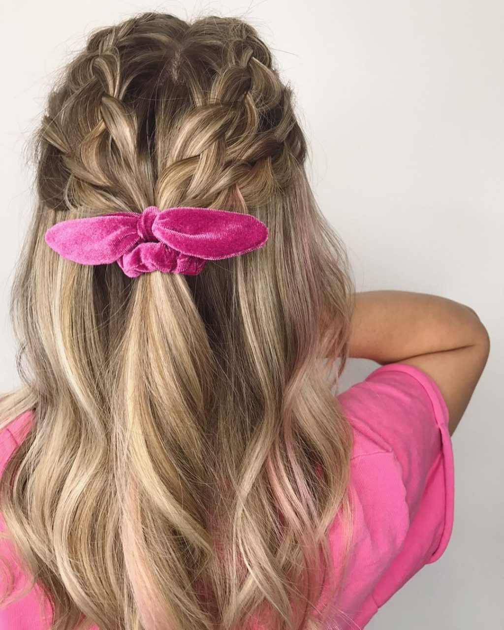 braided hair with a pink bow